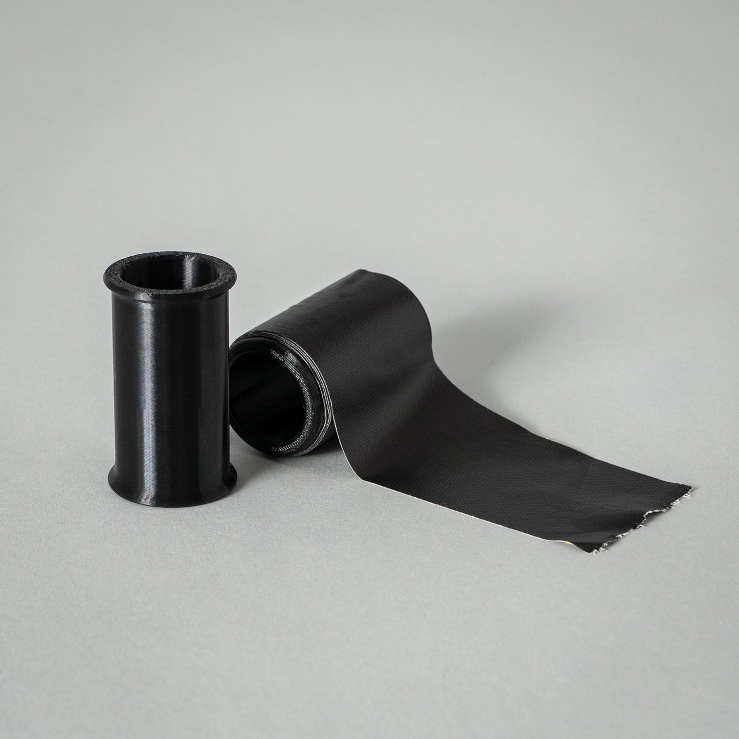 Schwarze 50mm Klebebandrolle von setbedarf, hochwertige Verpackungs- oder Bastelbandrolle, auf weißem Hintergrund.
